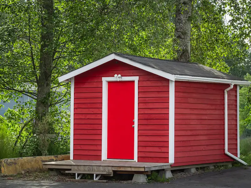 Small red wooden storage shed with white trim and a red door in Orlando, FL
