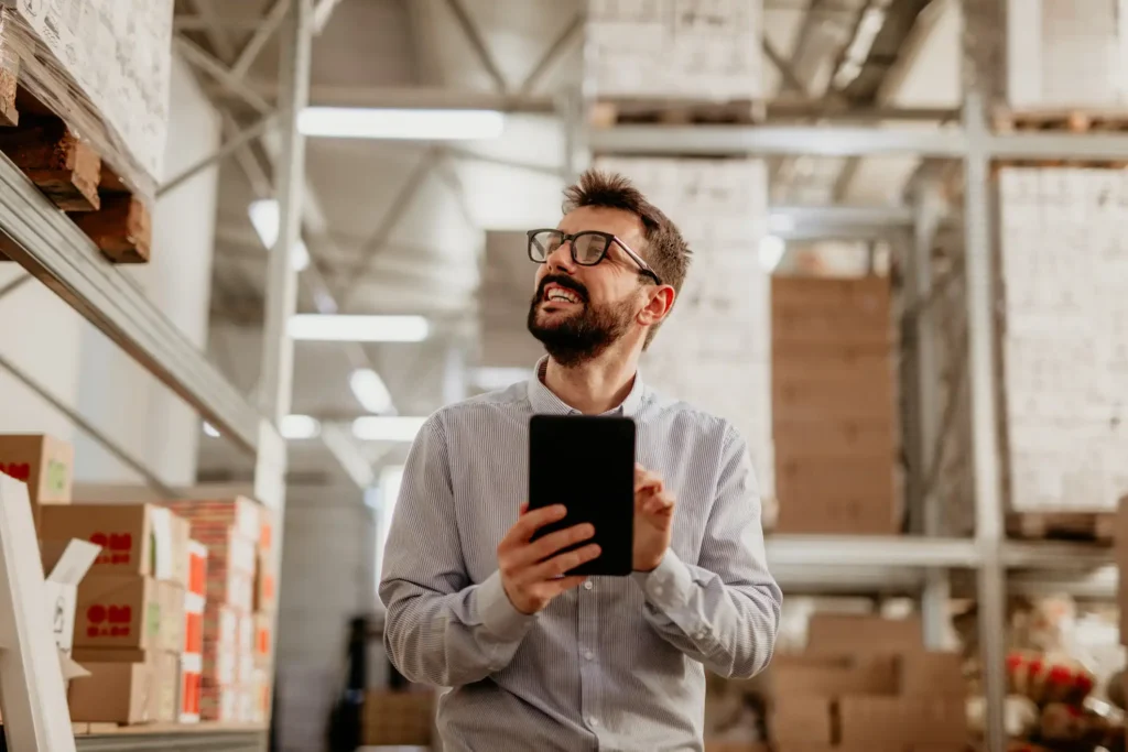 Person recording warehouse inventory with industrial shelving and stacked boxes in Orlando, FL